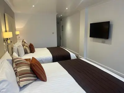a hotel room with two beds and a flat screen tv at Sorrento Hotel & Restaurant in Cambridge