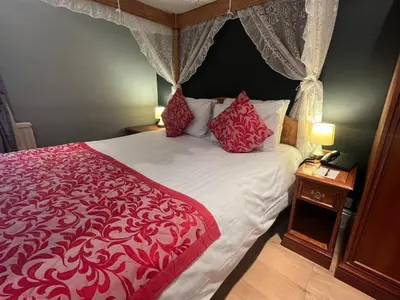 a bedroom with a bed with a red and white bedspread at Sorrento Hotel & Restaurant in Cambridge