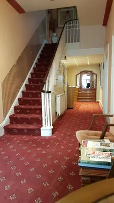 a staircase in a house with a red carpet at The Carlton Hotel in Ipswich