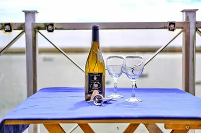 a bottle of wine and two glasses on a table at Finest Retreats - Kings Wharf - Luxury Riverside Home in Burnham on Crouch