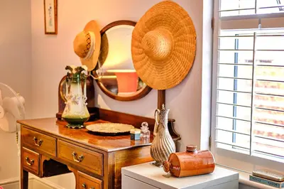 a dressing table with a mirror and a hat on it at Finest Retreats - Kings Wharf - Luxury Riverside Home in Burnham on Crouch