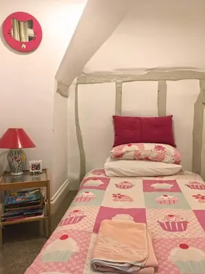 a bedroom with a bed with red pillows on it at Kingfisher Cottage - Woodbridge in Woodbridge