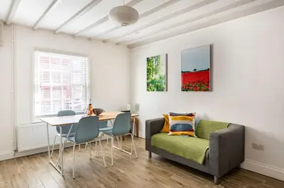 a living room with a couch and a table at Kingfisher Cottage - Woodbridge in Woodbridge
