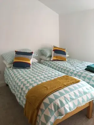 two beds sitting next to each other in a room at Kingfisher Cottage - Woodbridge in Woodbridge