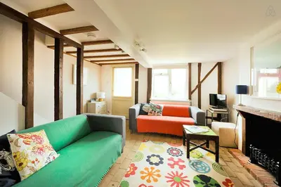 a living room with a couch and a fireplace at Period Cottage near Suffolk Coast and Forest in Tunstall