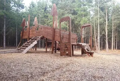 a wooden playground with a slide in a park at Period Cottage near Suffolk Coast and Forest in Tunstall
