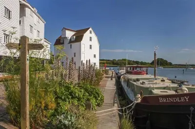 a boat parked next to a building and a house at Period Cottage near Suffolk Coast and Forest in Tunstall