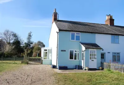 a blue and white house with a fence at Period Cottage near Suffolk Coast and Forest in Tunstall