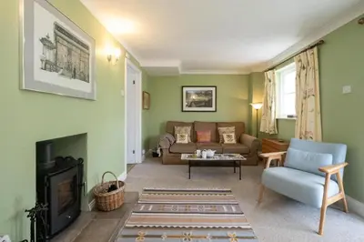 a living room with a couch and a fireplace at 8 Saxonfields in Snape