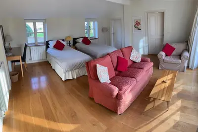 a living room with a couch and two beds at Field Cottage Bed and Breakfast in East Harling