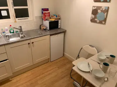 a small kitchen with a sink and a table at Field Cottage Bed and Breakfast in East Harling