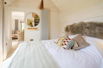 a bedroom with a white bed with two pillows on it at Mission Lodge in Thorpeness