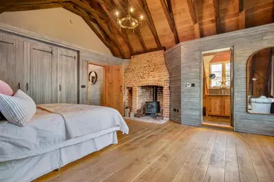 a bedroom with a bed and a fireplace at Bailiffs Cottage in Colchester
