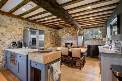 a kitchen with a table and a dining room at Bailiffs Cottage in Colchester