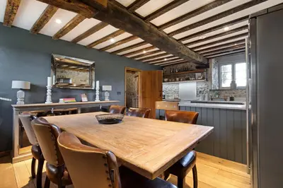 a kitchen with a wooden table and chairs at Bailiffs Cottage in Colchester