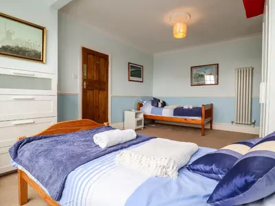 a bedroom with two beds and a bedroom with another bed at The Pink House in Felixstowe