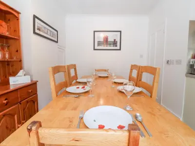 a dining room table with plates and wine glasses at The Pink House in Felixstowe