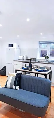 a living room with a blue couch in a kitchen at Suffolk Cosy Corner with free parking, 10min walking to town centre in Bury Saint Edmunds
