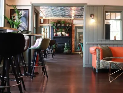 a bar with chairs and tables in a room at The New Boar in Theydon Bois
