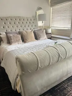 a large bed with a large headboard in a bedroom at The New Boar in Theydon Bois
