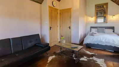 a living room with a bed and a couch at Lake View Lodges The Melford in Long Melford