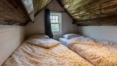 two beds in a small room with a window at Lake View Lodges The Melford in Long Melford
