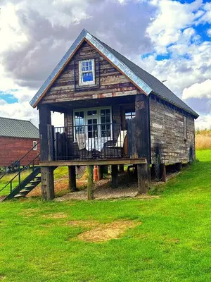 a small cabin with a porch on a grass field at Lake View Lodges The Melford in Long Melford