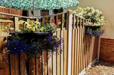 a wooden fence with potted plants on it at Oak Tree View - relax, reconnect, explore or work in East Harling
