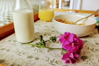 a table with a bowl of milk and flowers on it at Oak Tree View - relax, reconnect, explore or work in East Harling