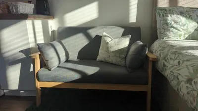 a chair with pillows on it next to a bed at Oak Tree View - relax, reconnect, explore or work in East Harling