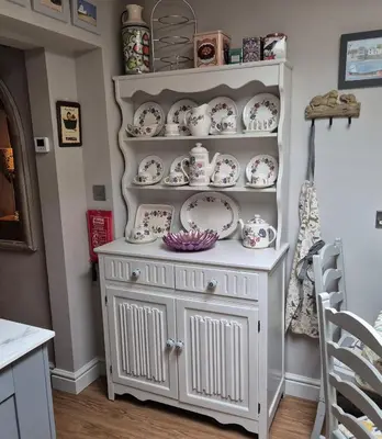 a white hutch with plates and bowls on it at Shoemakers Cottage, Halesworth in Halesworth