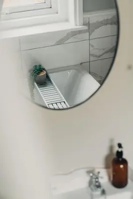 a mirror over a sink with a plant on a shelf at Pier View Felixstowe - Sea View, 50m from the beach in Felixstowe