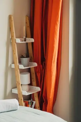 a room with a bed and shelves next to a curtain at Pier View Felixstowe - Sea View, 50m from the beach in Felixstowe