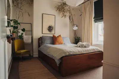 a bedroom with a bed with pillows and a chair at Pier View Felixstowe - Sea View, 50m from the beach in Felixstowe