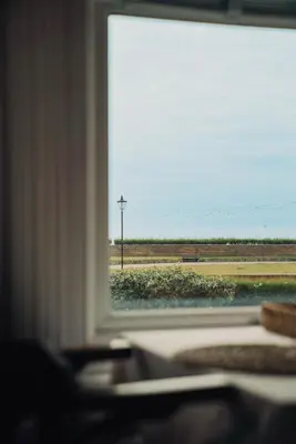 a window with a view of a field from a train at Pier View Felixstowe - Sea View, 50m from the beach in Felixstowe