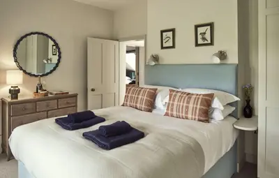a bedroom with a large bed with two pillows on it at Bridge House at Woodhall Estate in Hertford