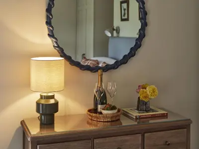 a table with a lamp and a mirror on it at Bridge House at Woodhall Estate in Hertford