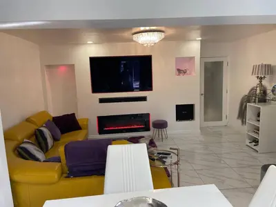 a living room with a yellow couch and a fireplace at Luxurious 2 bed home in Basildon in Basildon