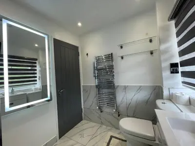 a bathroom with a toilet and a sink and a window at Luxurious 2 bed home in Basildon in Basildon