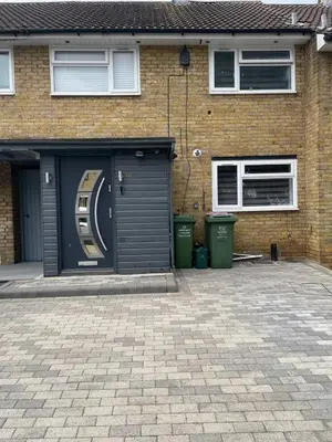 a garage with two trash cans in front of a house at Luxurious 2 bed home in Basildon in Basildon
