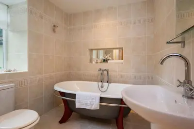 a bathroom with a tub and a sink and a toilet at The Granary at Pannels Ash Farm in Sudbury