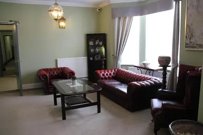 a living room with a couch and chairs and a table at Centennial Hotel in Cambridge