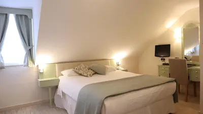 a bedroom with a bed and a desk and a mirror at Centennial Hotel in Cambridge