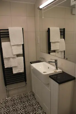 a bathroom with a sink and a mirror and towels at Centennial Hotel in Cambridge