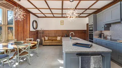 a kitchen and living room with a table and chairs at Darcy West in Colchester