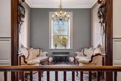 a living room with chairs and a chandelier at Darcy West in Colchester