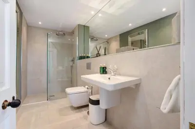 a bathroom with a sink and a shower and a toilet at Darcy West in Colchester