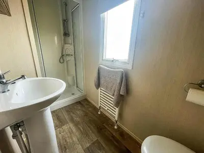 a bathroom with a sink and a window at 2br-sleeps6-wifi-freeparking-holidaypark in Clacton-on-Sea