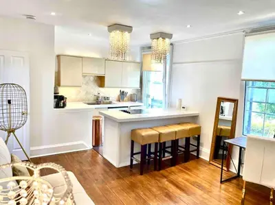 a kitchen with a counter and some stools in it at EMMANUEL HOUSE LOVELY 1 - BEDROOM APT IN HISTORICAL BUILDING CENTRAL CAMBRIDGE in Cambridge