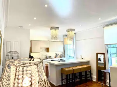a kitchen with a counter and some chairs in it at EMMANUEL HOUSE LOVELY 1 - BEDROOM APT IN HISTORICAL BUILDING CENTRAL CAMBRIDGE in Cambridge